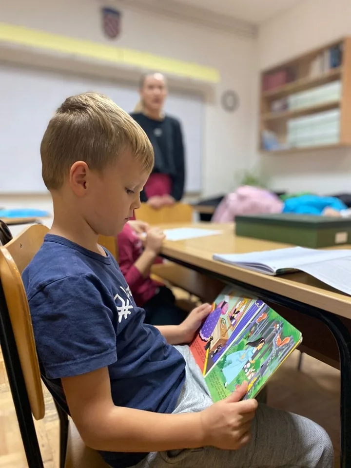 Učenik čita knjigu.